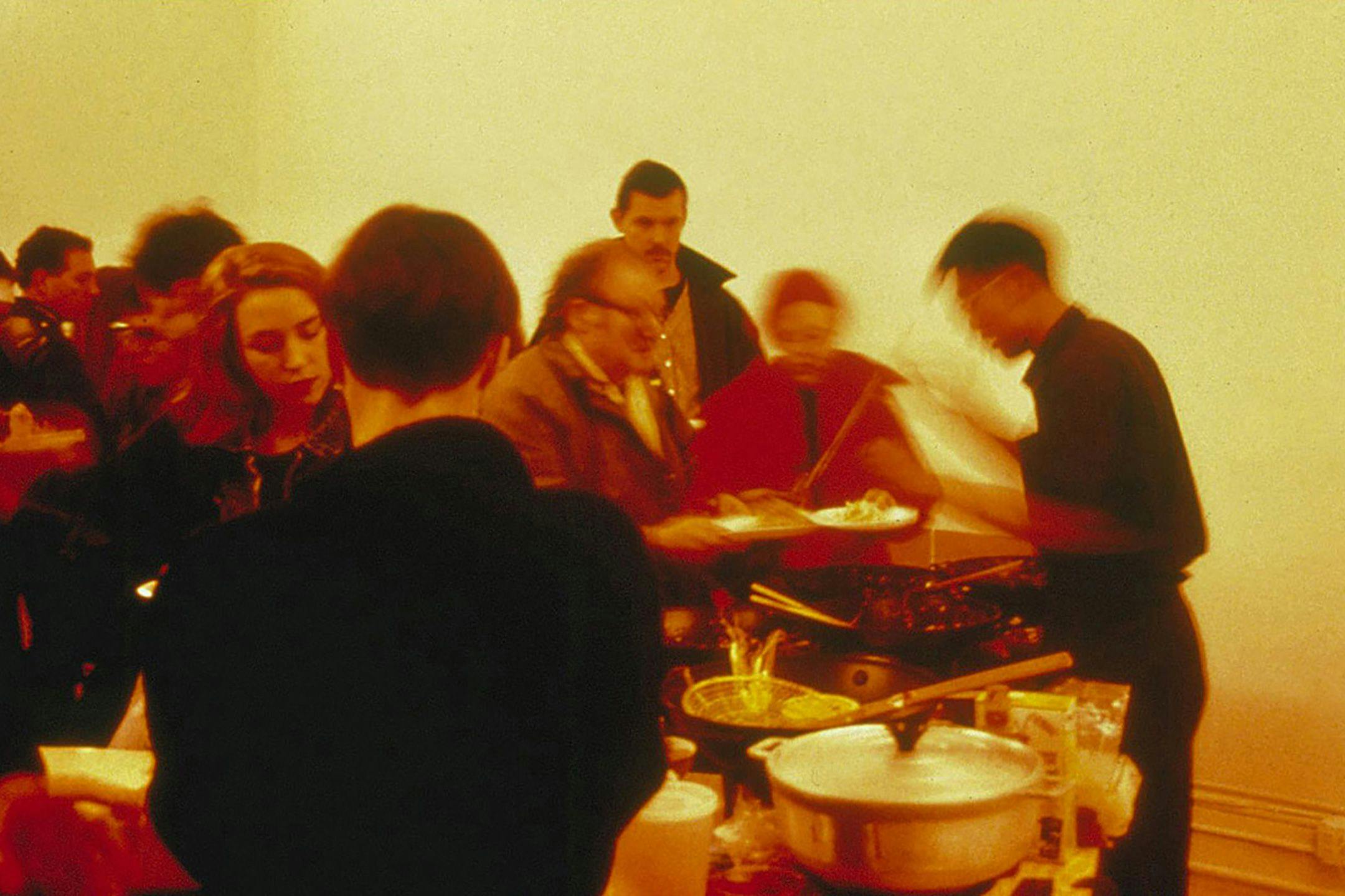 An installation view of viewers interacting with a mixed media installation by Rirkrit Tiravinija, titled untitled (pad thai), dated 1990.