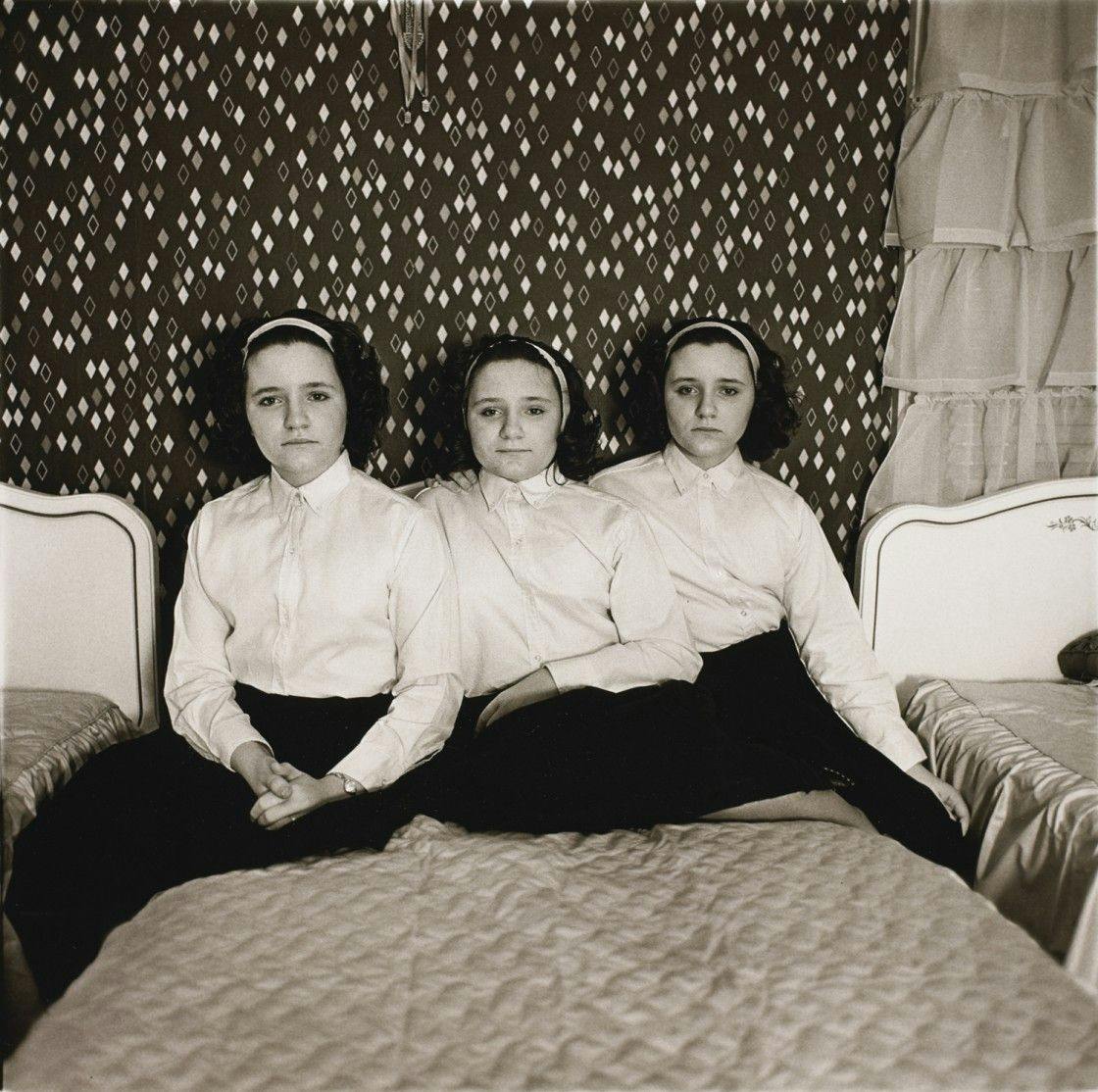 A photograph by Diane Arbus, titled Triplets in their bedroom, N.J. 1963, dated 1963. Copyright The Estate of Diane Arbus