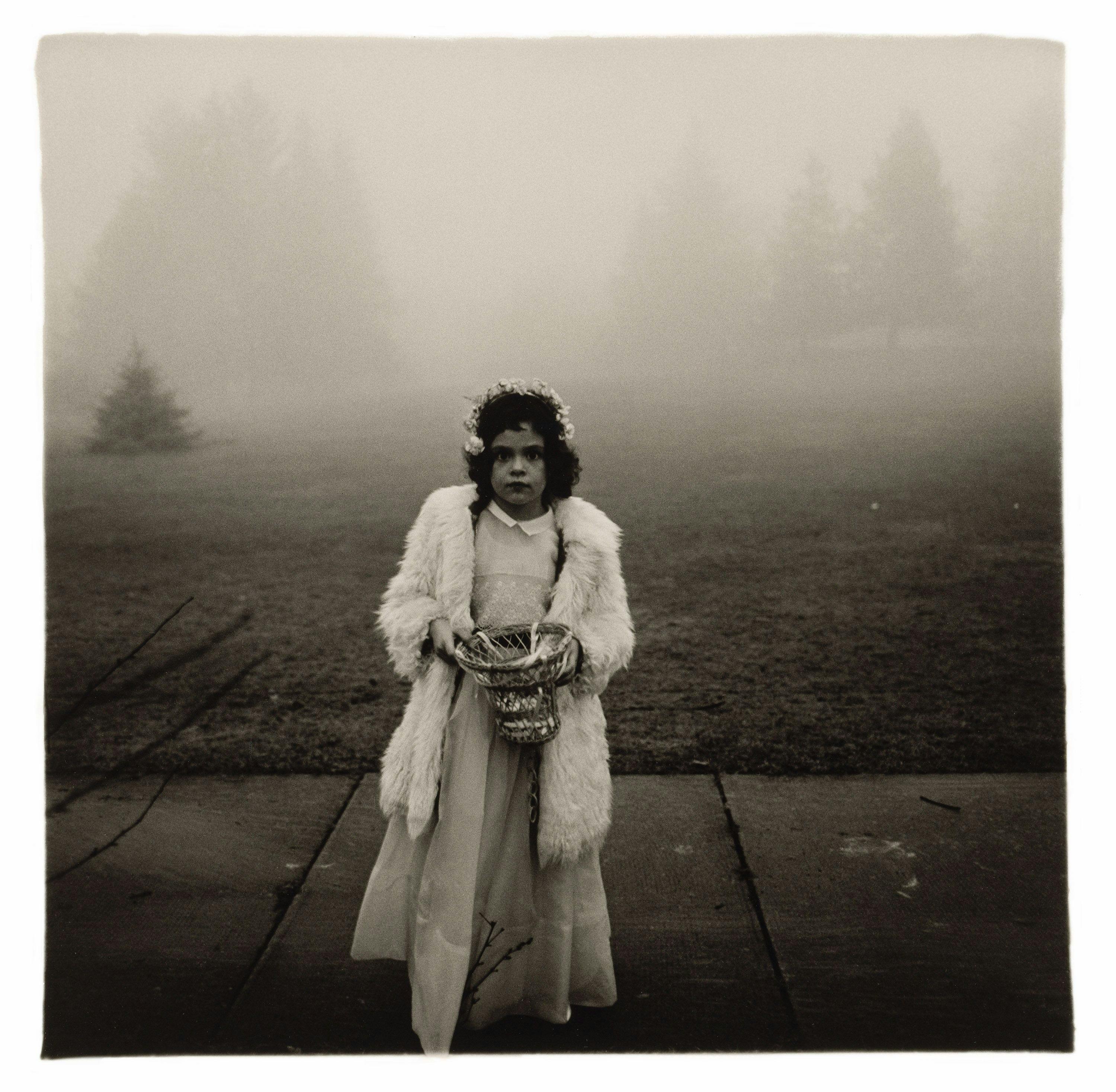 A gelatin silver print by Diane Arbus, titled A flower girl at a wedding, Conn. 1964, dated 1964.