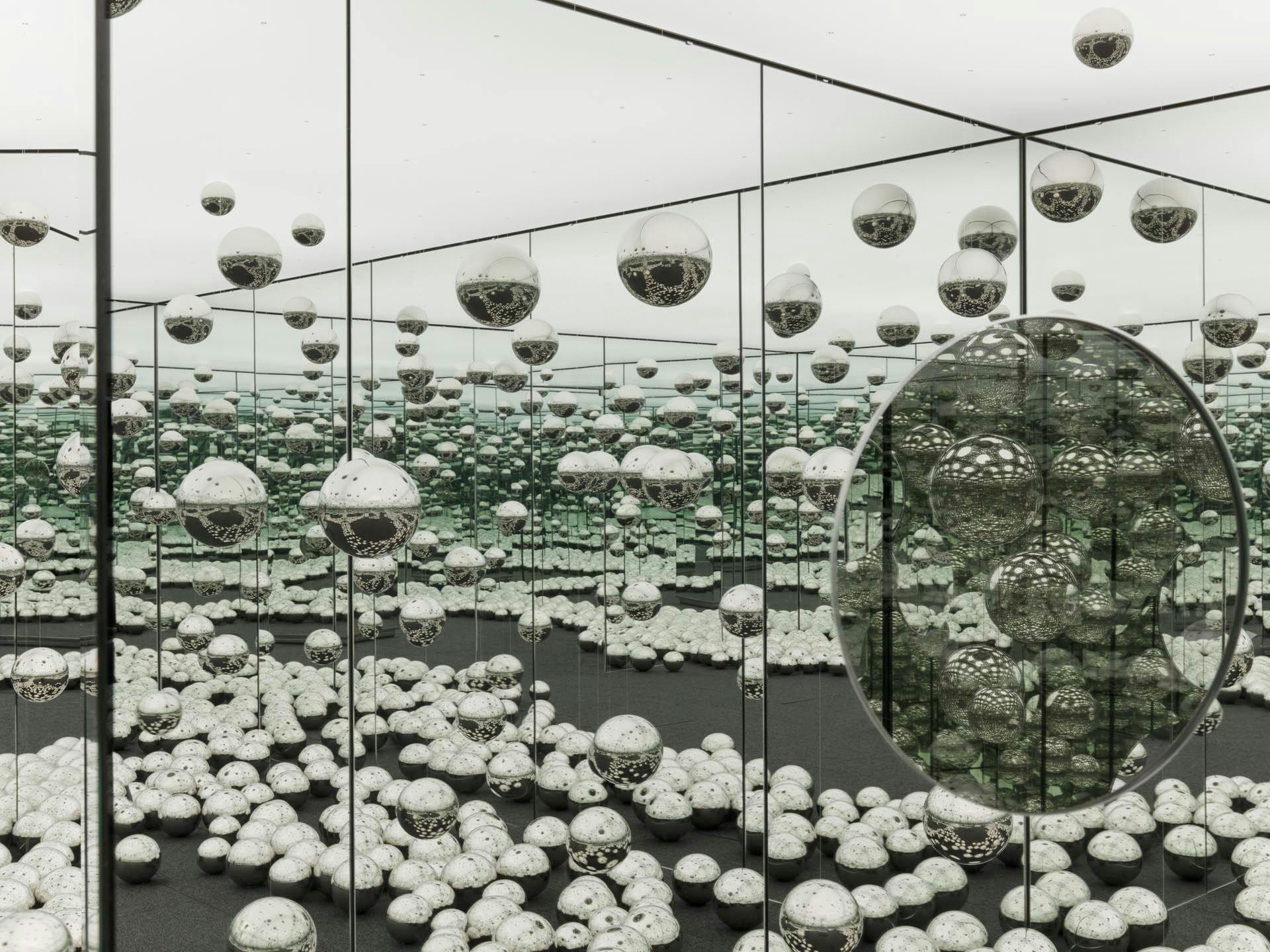 A view of an experiential installation by Yayoi Kusama, comprised of mirrors, wood, LED lighting system, metal, steel balls, and carpeting, titled Infinity Mirrored Room - Let's Survive Forever, dated 2017.