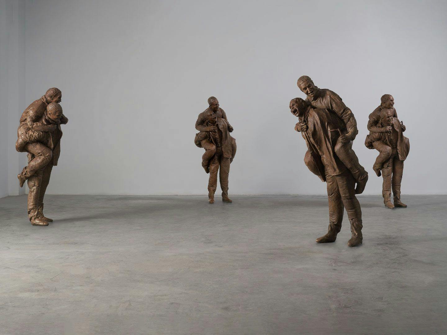 A mixed media sculptural installation by Juan Muñoz, titled Four Piggybacks with knives, dated 2001. 