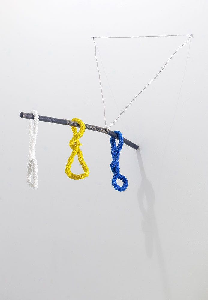 A mixed media, wall-mounted sculpture by Al Taylor, titled Layson a Stick (Blue Balls), dated 1992.