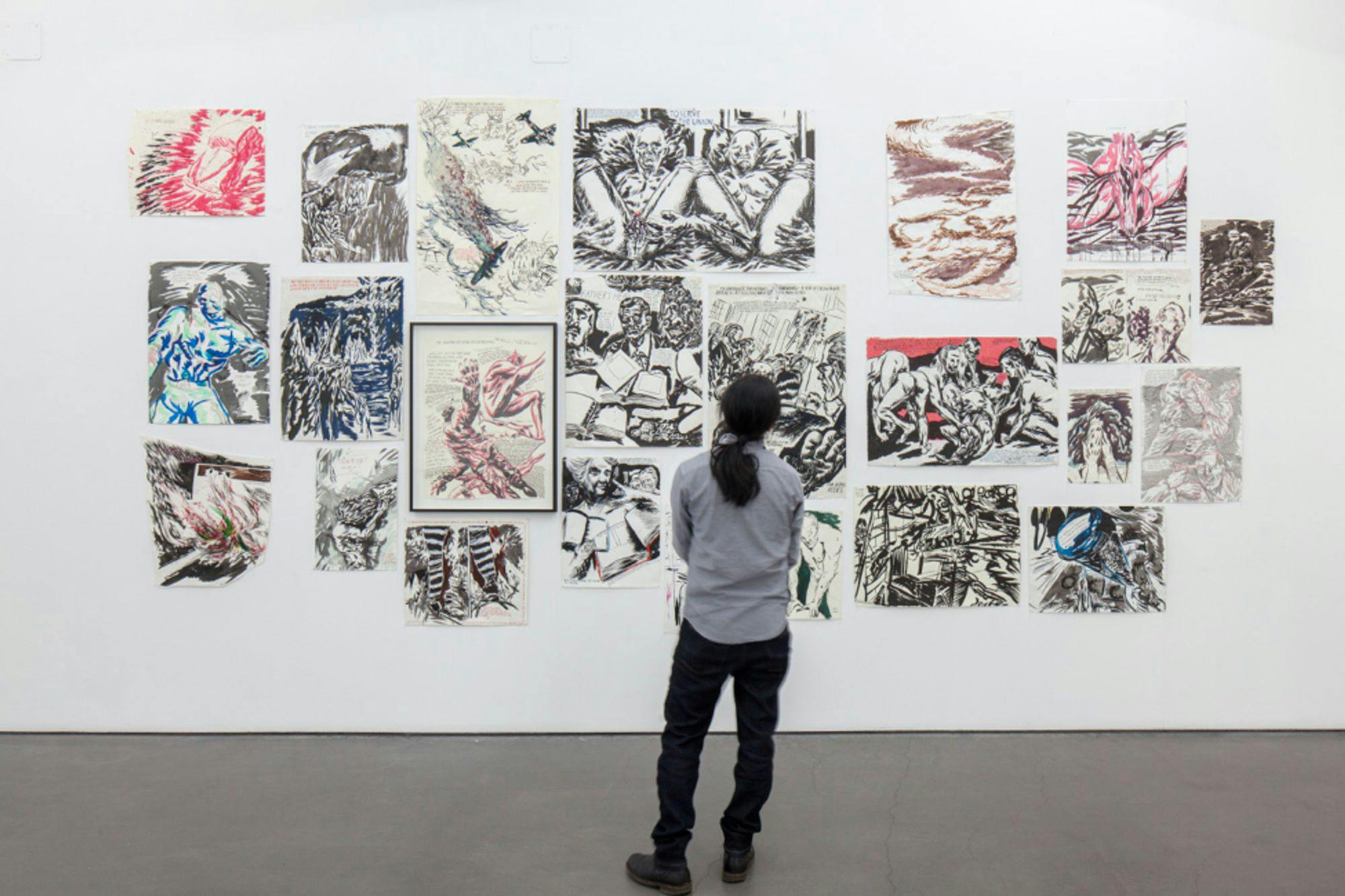 A man standing in front of several Raymond Pettibon drawings installed at the Deichtorhallen Hamburg in 2016