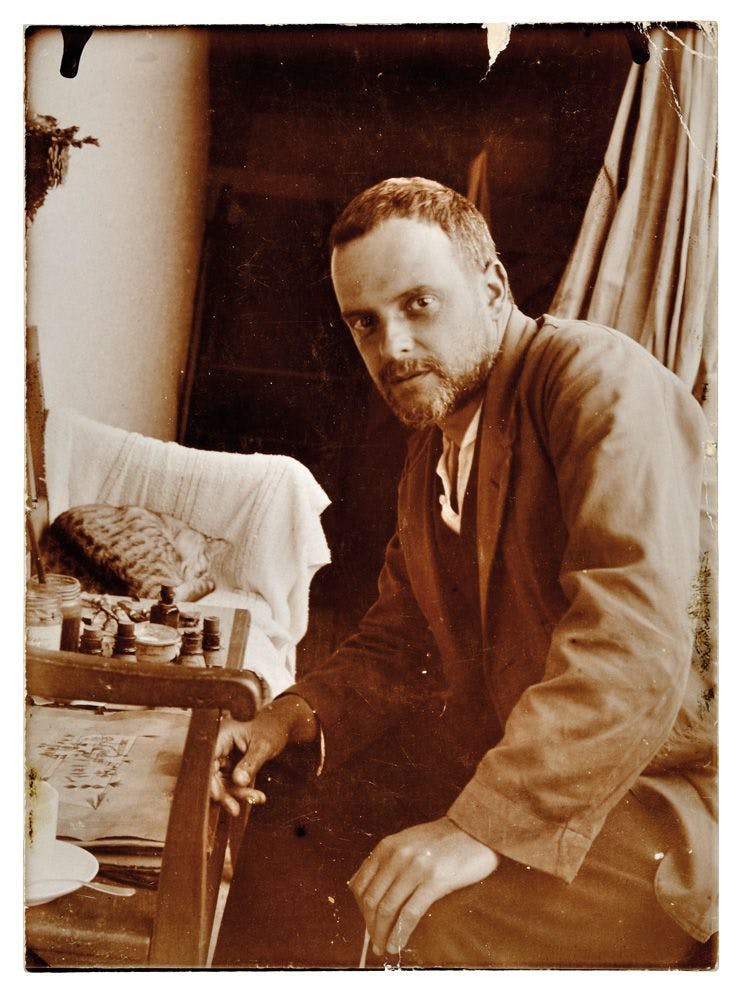 A photo of Paul Klee in his studio with his cat, dated 1923.