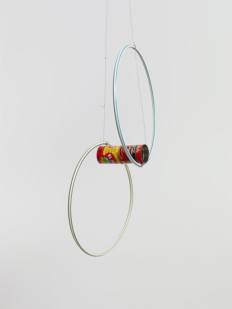 A mixed media hanging sculpture by Al Taylor, titled Cans & Hoops, dated 1993.