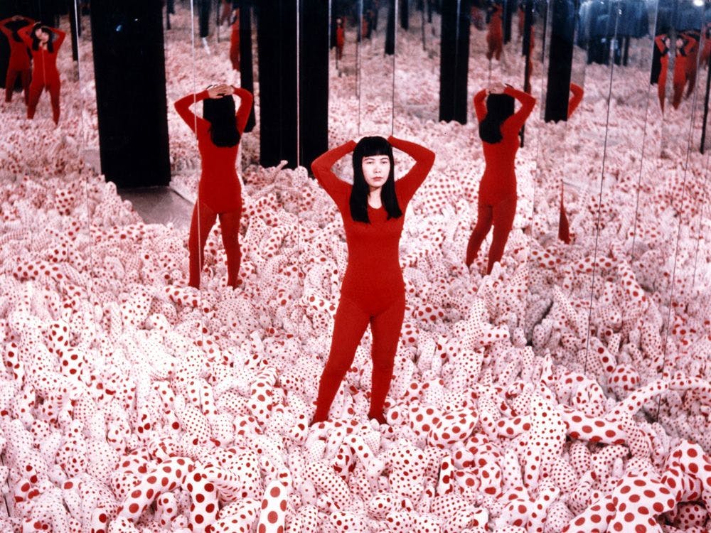 A photograph of Yayoi Kusama with her work, Infinity Mirrored Room ‚Äì Phalli‚Äôs Field, dated 1965.